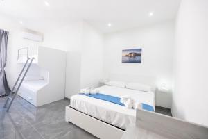 a white bedroom with a bed and a staircase at I Due Moli Vibo Marina in Vibo Valentia Marina