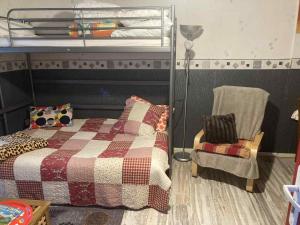 a bedroom with a bunk bed and a chair at Studio MARMOTTES au RDC a HYPER centre du Mont DORE in Mont-Dore