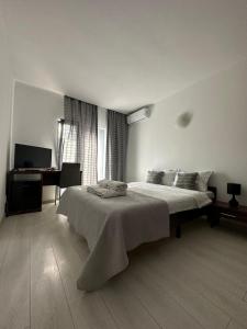 a white bedroom with a bed and a desk at Vila Medusa in Vama Veche