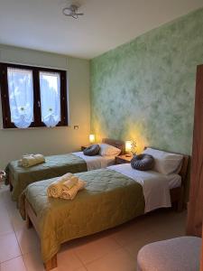 a room with three beds with towels on them at Il Sogno di Olly - Assisi in Santa Maria degli Angeli