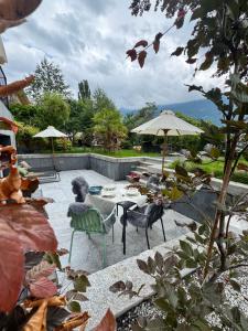 a patio with a table and chairs and umbrellas at Art Residence, Gina Sommer in Brienz