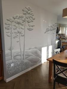 a mural of trees on a wall in a kitchen at "Les Logis d'Argent Mimizan Chambre d'hôte climatisée avec WC, SDB, TV, Wifi, Option Petit Déjeuner , Parking in Mimizan