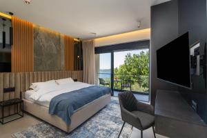 a bedroom with a bed and a tv and a balcony at Villa Blue Sunset in Brsečine