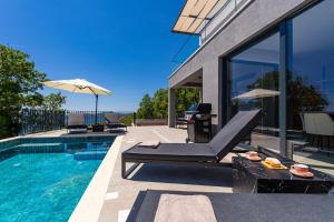 a house with a swimming pool and a patio at Villa Blue Sunset in Brsečine