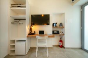 a room with a desk with a laptop and a chair at Oikos - Charm & Relax Procida in Procida