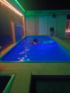 a person swimming in a pool in a room at Casa de ferias Tarciane Horizonte Ceara in Horizonte