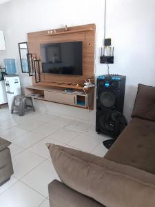 a living room with a couch and a tv at Casa de ferias Tarciane Horizonte Ceara in Horizonte