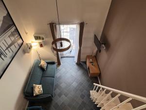 a living room with a green couch and a staircase at Pietranera - Sicilian Escape Retreat in Linguaglossa