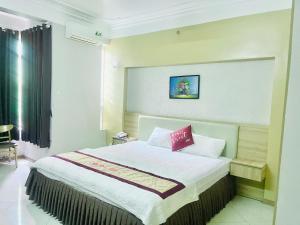 a bedroom with a large bed with a red pillow at Hotel Hoà Bình Riverside Văn Phú in Hà Ðông +22 photos