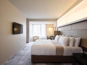 a hotel room with a large bed and a desk at Hotel Realm in Canberra