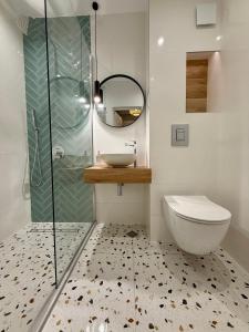 a bathroom with a toilet and a sink and a mirror at Апартамент Vista Al Mar in Pomorie