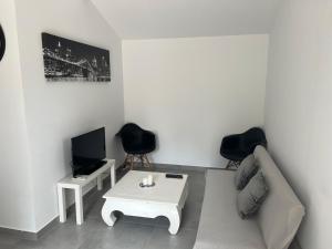 a living room with a couch and a table and a tv at Appartement T2 dans le Luberon in Cavaillon +7 photos