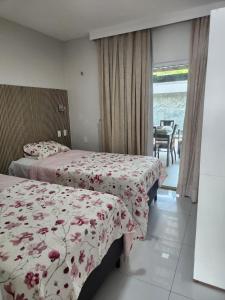 a bedroom with two beds and a view of the ocean at Casa Odara - Lençóis Maranhenses - Barreirinhas MA in Barreirinhas +41 photos