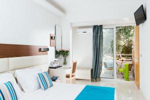 a bedroom with a bed and a view of a patio at Elounda Akti Olous (Adults Only) in Elounda
