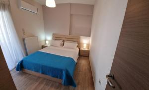 a small bedroom with a bed with a blue blanket at Onda Blu Deluxe Loutraki in Loutraki +39 photos