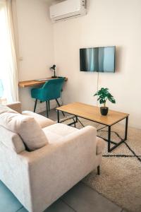 a living room with a couch and a table at Studio Le Cosy Consulat - 2 voyageurs in Saint-Denis