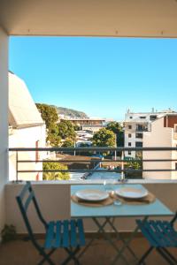 a table and chairs on a balcony with a view at Studio Le Cosy Consulat - 2 voyageurs in Saint-Denis