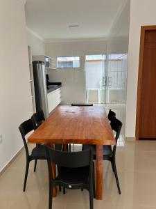 una sala da pranzo con tavolo e sedie in legno di VISTA MAR 3 apt6 a Porto Seguro
