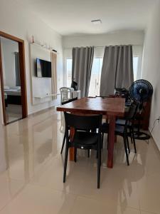 una sala da pranzo con tavolo e sedie in legno di VISTA MAR 3 apt6 a Porto Seguro