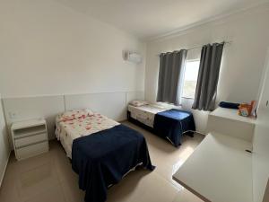 una piccola camera da letto con due letti e una finestra di VISTA MAR 3 apt6 a Porto Seguro