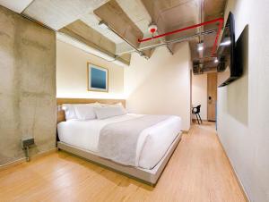 サバネタにあるHotel Once22の白いベッドとテレビのある寝室 +35枚の写真