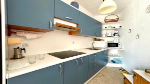 a kitchen with blue cabinets and a sink at Welooveyou Honey in Costa Calma