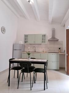 a kitchen with a table and chairs in a room at Purtusu's House in Pachino