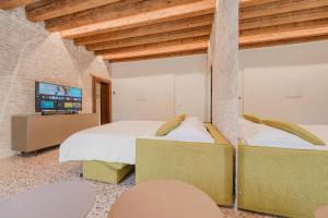 a bedroom with two beds and a tv in it at San Matteo Rialto Terrace Apt in Venice