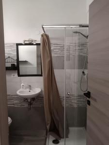 Un baño con ducha de cristal y lavabo. en Casa Edo, en Castelsardo