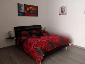 Un dormitorio con una cama con una manta roja. en Casa Edo, en Castelsardo