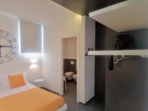 una camera da letto con un letto e un orologio a parete di PM 5 Via Salita di Castelvecchio a Matera