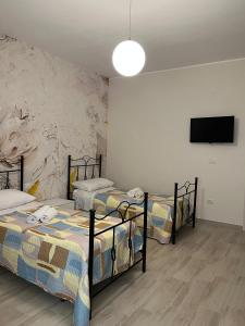 a room with three beds and a flat screen tv at Al Solito Posto Affittacamere 