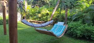 two chairs in a hammock in a garden at Villa do Cajueiro Imbassaí by LVF in Imbassai
