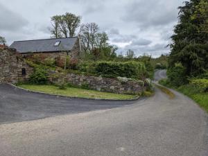 a winding road in front of a stone house at Arrigle Cottage in Kilkenny +2 photos