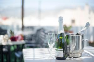 a bottle of wine and two glasses on a table at Hotel Toboso Chaparil in Nerja