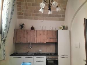 a kitchen with wooden cabinets and a refrigerator at Piazza Vittorio 30 in Trapani