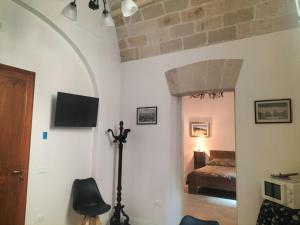 a living room with a bed and a tv on the wall at Piazza Vittorio 30 in Trapani +10 photos