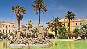 a statue in a fountain in front of a building at Piazza Vittorio 30 in Trapani
