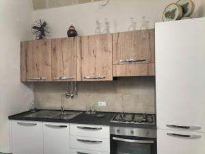 a kitchen with wooden cabinets and a stove top oven at Piazza Vittorio 30 in Trapani
