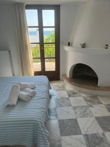 スキロスにあるAegean Houseのベッドルーム1室(タオル、暖炉付)