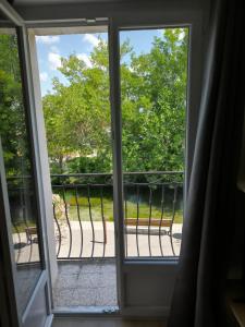 una puerta abierta a un balcón con vistas en La maison du quai, en LʼIsle-sur-la-Sorgue