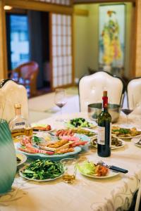 a table with plates of food and a bottle of wine at 寝室から太平洋を望む貸切別荘in海友荘 無料炭火BBQスペースと駐車場付 in Shirahama +23 photos