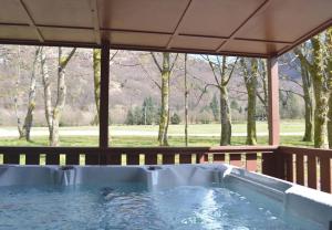 a hot tub on a deck with a view of a field at Stratheck Holiday Park in Dunoon