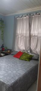 1 cama con cabecero blanco y almohada roja en Casa COP30, en Ananindeua 26 fotos más