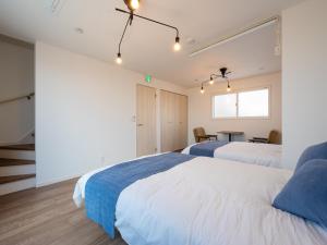 een slaapkamer met twee bedden en een tafel erin bij Town House Suma in Kobe