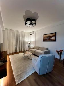 a living room with a couch and a blue chair at Oakline Apartments in Pristina