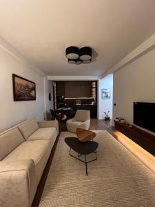 a living room with a couch and a table at Oakline Apartments in Pristina