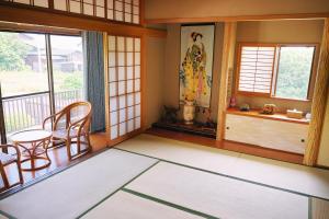 a room with a balcony with a table and chairs at 天然温泉付別荘in海友荘 in Shirahama