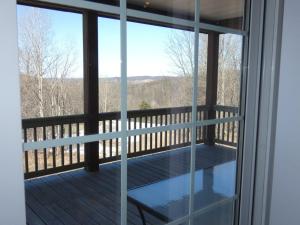 a screened in porch with a view of the mountains at Sunny Days at Shanty Creek in Bellaire