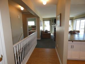 a hallway of a home with a staircase and a living room at Sunny Days at Shanty Creek in Bellaire